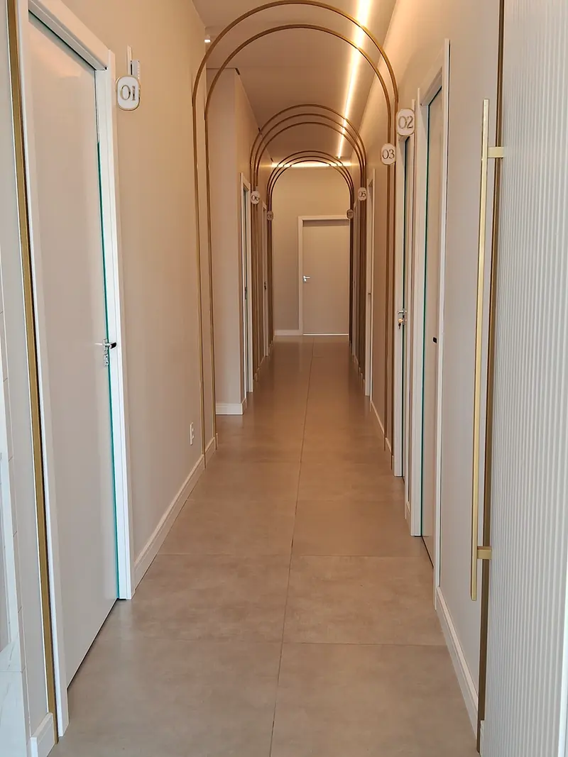 Corredor das salas de atendimento, com arcos iluminados